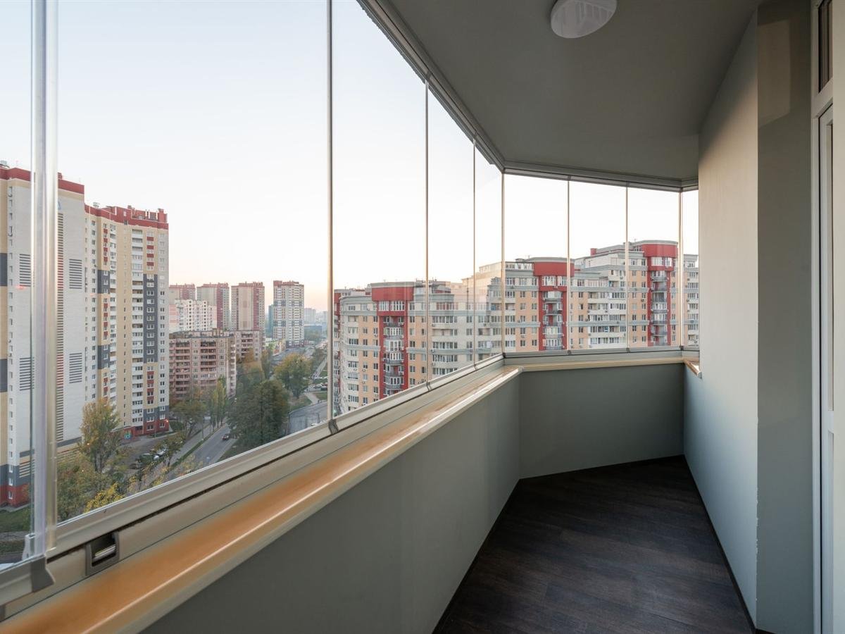 Sacada com cortina de vidro e vista para a cidade